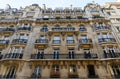 The facade of traditional French house with typical balconies and windows. Paris.