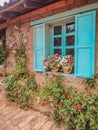 Facade of a traditional house with light blue shutters and ivy flowers in Ecuador Royalty Free Stock Photo