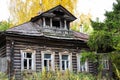 Facade of a traditional Russian house made of wooden logs izba with a balcony in autumn. Gorokhovets