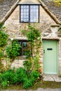 Facade of traditional small cottage home in Bibury village, Cotswolds, Egland, UK Royalty Free Stock Photo