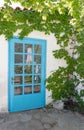 Facade of traditional white greek house with blue door and window and reflected on glass Royalty Free Stock Photo