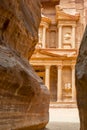 The facade of the Treasury Al Khazneh carved into the red rock, seen from the Siq, Petra, Jordan Royalty Free Stock Photo