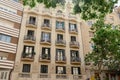 Facade of a typical apartment building in Barcelona, Spain. Exterior building with balconies and window shutters