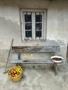 Facade of a typical house with a hoe, a basket full of apples, a bench and a basin with chestnuts, Gratila, Nava, Asturias, Spain