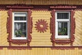 Facade of typical old rural Russian house with carved wooden decorations and architraves.