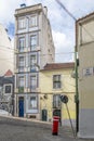 Facade of a vintage five-story building in a narrow street with tram tracks in the historic center of Lisbon