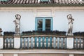 Facade vintage houses with balconies, flowers and statues