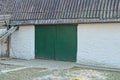 Facade of a white brick garage with green iron gates