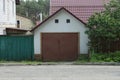 Facade of a white garage with brown metal gates