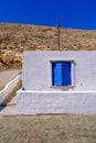 Facade of a whitewashed house with blue windows