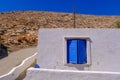 Facade of a whitewashed house with blue windows