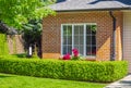 Facade with window of a brick house with a patio on a bright, sunny day in Vancouver, Canada House front door