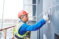 Facade worker plastering external wall of building