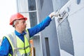 Facade worker plastering external wall of building