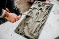 Facade builder working on stone tiles. Details of worker using mortar for stone installation