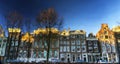 Facades of Amsterdam houses reflected in a pool of water