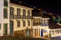 Facades of houses in colonial architecture on an old cobblestone street at night Royalty Free Stock Photo