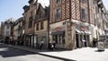 Facades of houses in old city in Europe, bottom view. Action. Beautiful street with walking people, restaurants, beige