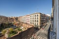 Facades of old residential buildings at a crossroads with cobbled paths, balconies and a large wall of a monastery with a large Royalty Free Stock Photo