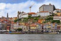 Facades of traditional houses with azulejo tile in Ribeira and tourist rabelo boats across the Douro in Porto, Portugal Royalty Free Stock Photo