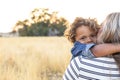 The face of an Adorable curly haired African American boy in the arms of his mother