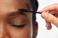 Face of african woman and hand with mascara brush Royalty Free Stock Photo