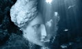 Face of ancient statue on a underwater background with corals and fish. Art, adventure, underwater archeology concept.