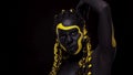 Face art. Dancing woman with black and yellow body paint. Young african girl with colorful bodypaint. An amazing afro