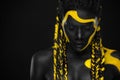 Yellow and black body paint. Woman with face art. Young girl with colorful bodypaint. An amazing afro american model Royalty Free Stock Photo