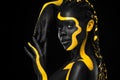 Yellow and black body paint. Woman with face art. Young girl with colorful bodypaint. An amazing afro american model Royalty Free Stock Photo