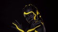 Face art. Dancing woman with black and yellow body paint. Young african girl with colorful bodypaint. An amazing afro