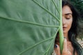 Face attractive young woman against a large green leaf tropical tree Royalty Free Stock Photo