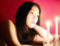 Face bathed in candlelight, a beautiful girl anticpates Valentine` Day