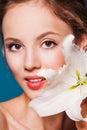 The face of a beautiful girl with fresh flower lily Royalty Free Stock Photo