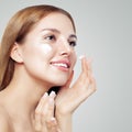 Face of a beautiful girl with perfect skin. Young woman applyng moisturizing cream. Concept of beauty, creams, skincare Royalty Free Stock Photo