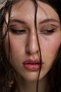 The face of a beautiful young girl with wet black hair close-up. Eastern appearance. Nude makeup, natural skin. Royalty Free Stock Photo