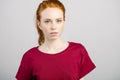 Beautiful young redhead girl with clean fresh face and neutral emotions close up Royalty Free Stock Photo