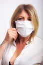 face of blond haired woman with closed eyes, mature woman with white background and white shirt with health mask