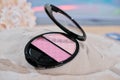 face blush on a sandy beach. summer waterproof cosmetics. pink shades of cosmetic for face,