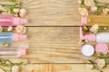 Face and body cosmetics in pink bottles with fresh roses on a natural wooden background. creams and lotion. spa. top view. space f Royalty Free Stock Photo