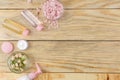 Face and body cosmetics in pink bottles with fresh roses on a natural wooden background. creams and lotion. spa. top view. space f Royalty Free Stock Photo