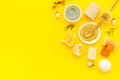 Face, body skin care homemade ingredients - cosmetic clay, brushes, homemade soap, scrub, herbs on a yellow background -