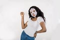 Face care and beauty treatments. Smiling pretty African woman with a cloth paper sheet moisturizing mask on her face Royalty Free Stock Photo