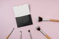 Face Charcoal Oil Blotting Paper with wooden makeup brushes on purple isolated background. Protable Face Wipes, makeup tools, Royalty Free Stock Photo