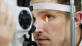 Face close-up , man doing eye test with non contact tonometer, cheking vision, intraocular pressure at optical clinic