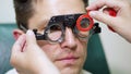 face close-up , ophthalmologist examining patient man with optometrist trial frame, visual inspection device. male