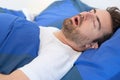 Man in bed suffering for sleep apnea syndrome