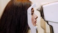 Face close-up , woman doing eye test with non contact tonometer, cheking vision, intraocular pressure at optical clinic