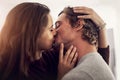 Face, couple and kiss for love, care and intimate moment for anniversary, honeymoon and bonding together at home. Happy Royalty Free Stock Photo