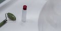 Face cream, face roller and lipstick near the sink on the counter in the bathroom Royalty Free Stock Photo